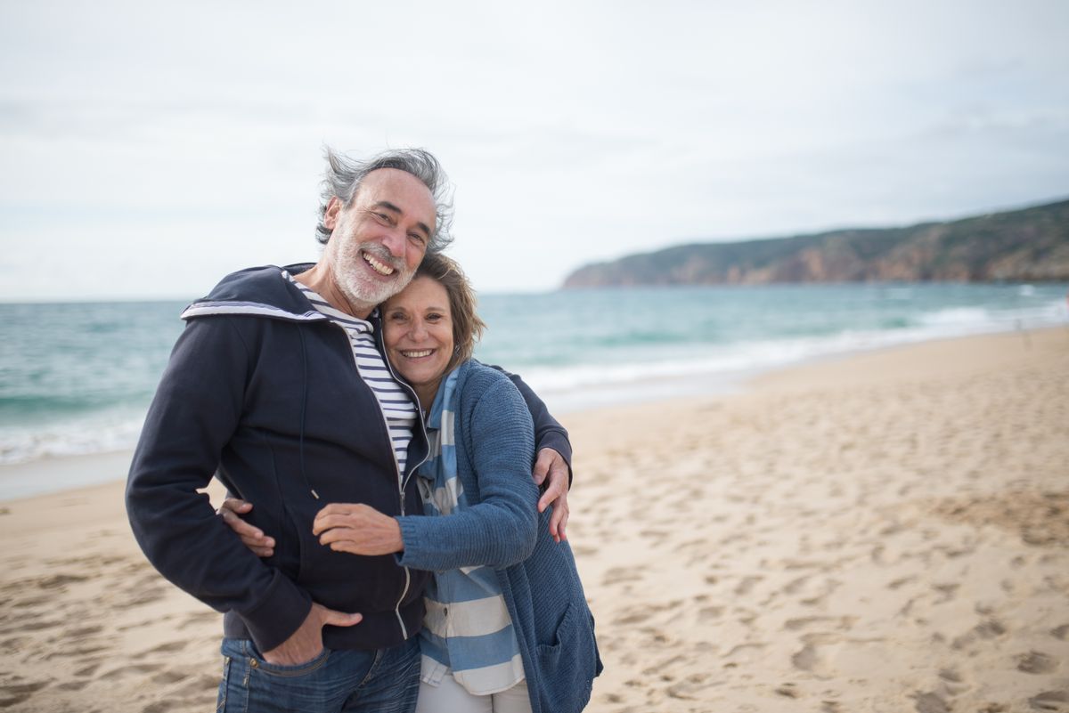 A happy senior couple embracing on the beach
